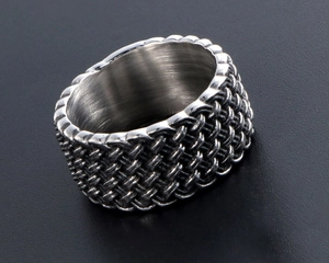 Macro detail of men's vintage woven texture titanium steel ring with polished inner band