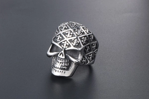Detailed close-up of a gothic skull ring with fleur-de-lis patterns and vintage steel texture