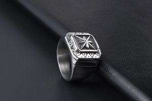 Macro shot of vintage steel square ring featuring star relief and brushed metal texture