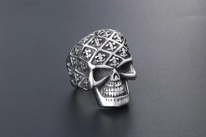 Detailed view of silver skull ring with gothic iris emblem and textured metal surface