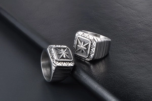 Close-up of vintage punk signet rings with star engraving on black leather background