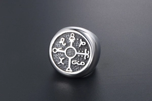 Macro shot of silver titanium ring featuring mystical symbols and circular engraved signet