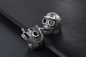 Detail view of vintage silver skull rings with caps and punk texture on leather surface