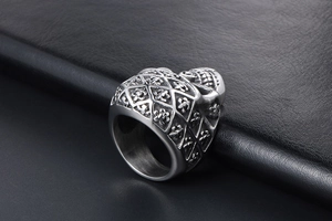 Detailed view of silver skull ring with gothic patterns and fleur-de-lis engravings