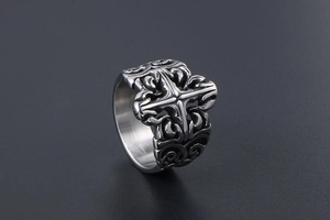 Macro detail of gothic titanium steel ring with relief cross and engraved scroll patterns