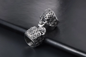 Close-up of vintage silver skull ring with fleur-de-lis engravings on a leather background