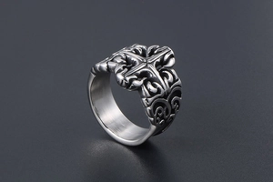 Close-up of vintage gothic cross relief on a stainless steel ring with floral patterns