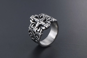 Macro detail of vintage stainless steel ring featuring gothic cross and floral engraving