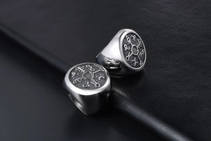 Close-up of retro silver titanium steel signet rings with occult symbol engravings