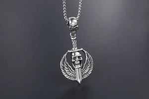 Gothic punk pendant with silver skulls, daggers, and feathered wings on grey background