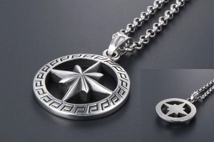 Macro shot of silver titanium steel circular pendant featuring an eight-pointed star and Greek pattern