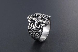 Macro shot of vintage titanium steel ring with gothic cross and baroque patterns