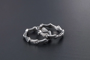 Detailed view of two interlocking silver titanium steel rings with bone-like design