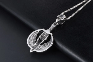 Close-up of vintage punk skull and battle axe pendant with metallic relief detail