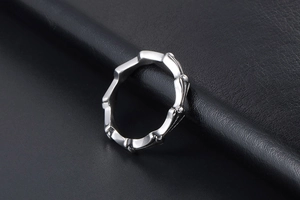Close-up of polished silver titanium steel ring with unique geometric bone texture