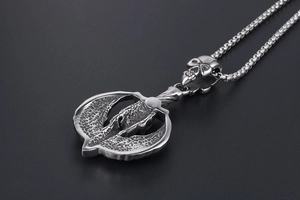 Macro shot of punk style skull pendant with textured metal finish and round box chain