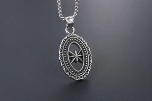 Macro detail of vintage hollow star pendant with intricate metalwork and beaded oval frame