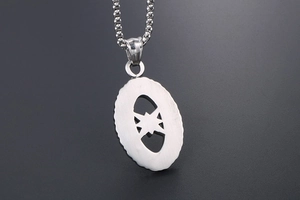 Detail of oval stainless steel pendant with hollow star pattern and silver ball chain