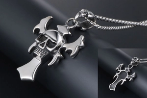 Macro detail of gothic skull and winged cross pendant in polished silver stainless steel