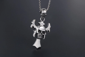 Detailed close-up of a gothic skull and cross pendant with a silver box chain necklace