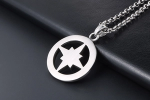 Close-up of titanium steel compass pendant with brushed metal finish and hollow star