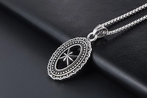 Macro detail of silver octagonal star pendant with vintage hollow design and box chain
