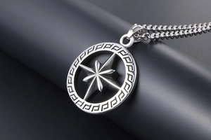Macro detail of silver titanium steel necklace with hollow star and Greek key pattern