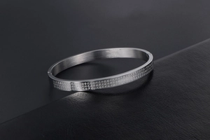 Macro shot of silver titanium steel bangle with engraved Buddhist Heart Sutra scriptures