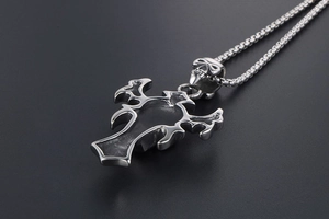 Detail of gothic stainless steel cross pendant with skull element and box chain link