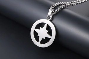 Macro shot of silver brushed stainless steel pendant with hollow star compass detail
