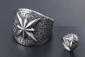 Détail macro d'une bague en acier titane avec relief d'étoile et texture martelée