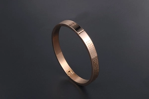 Detail of 24K gold-plated titanium bracelet showing Chinese Heart Sutra engraving