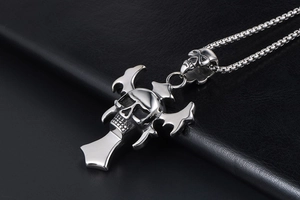 Macro shot of punk style stainless steel skull cross pendant on black leather
