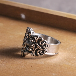Gothic vintage titanium steel ring with relief engraving on a wooden tray