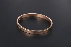 Macro detail of rose gold titanium steel bangle featuring fine engraved Chinese characters