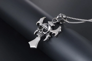 Close-up of gothic skull pendant with cross wings on a stainless steel box chain necklace