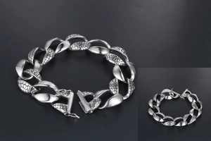 Detailed view of silver snake-pattern chain link bracelet in polished stainless steel