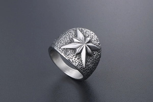 Vue latérale macro d'une bague en acier titane vintage avec étoile et texture martelée