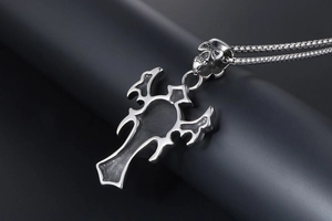 Detailed close-up of gothic skull pendant and hollow cross on dark steel chain