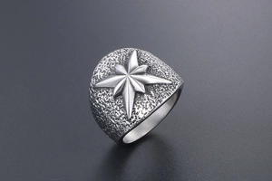 Gros plan d'une bague en acier titane avec étoile octogonale et texture martelée