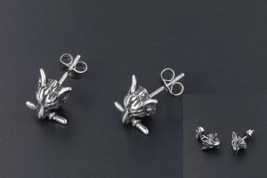 Macro shot of punk style wolf head stud earrings featuring vintage stainless steel texture