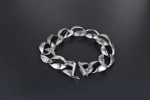 Close-up of polished silver metal chain bracelet with detailed snake skin texture