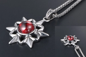 Close-up of vintage stainless steel star pendant with a large round red gemstone