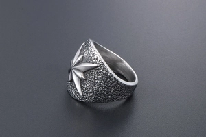 Détail d'une bague vintage en acier titane avec motif floral octogonal texturé