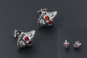 Detailed macro view of vintage gothic skull stud earrings with red rhinestone eyes