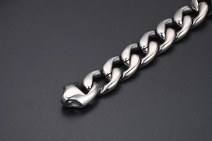 Close-up of polished silver titanium steel Cuban chain link with a chunky punk rock style