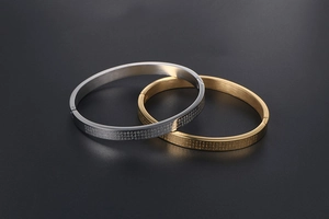 Detail of brushed 24K gold and silver titanium steel bangles with Heart Sutra engraving
