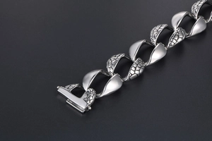 Macro detail of men's silver snake-scale textured bracelet with polished finish