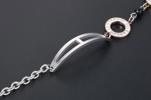 Detail of rose gold H-hollow charm bracelet with sparkling rhinestones and black bead