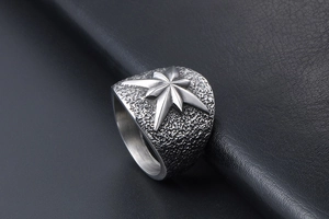 Détail de l'étoile octogonale sur bague en acier titane mat avec texture martelée